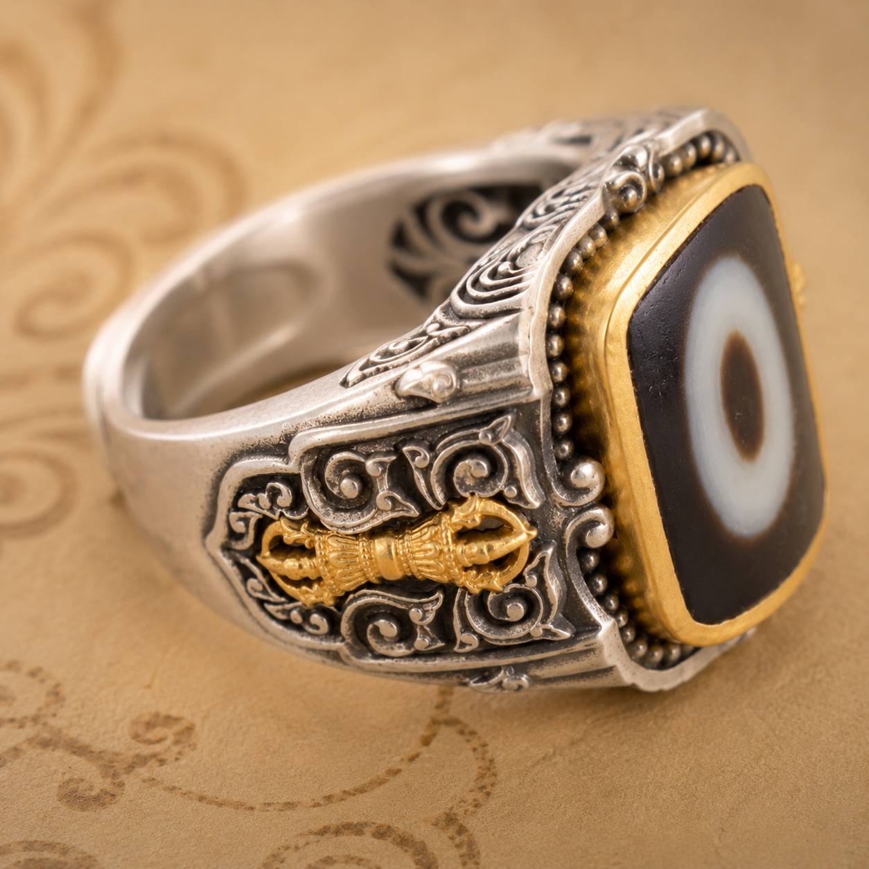 One-eyed dzi bead ring — side view showing hand-carved scrollwork and gold vajra