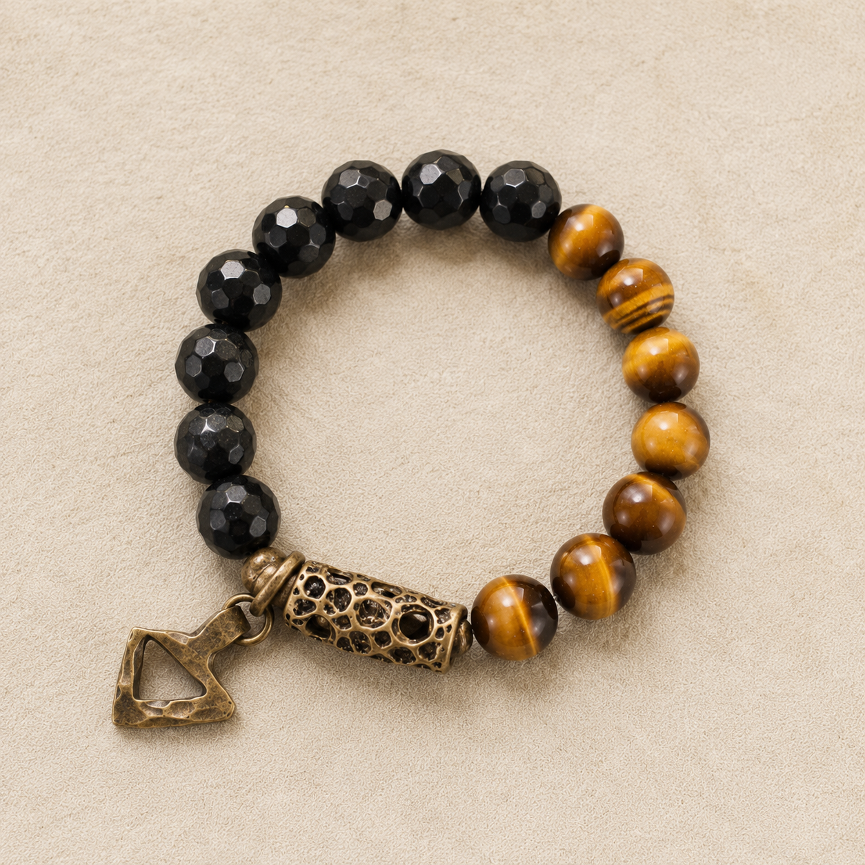 Tiger eye and black obsidian bracelet — flat view showing bronze barrel and charm